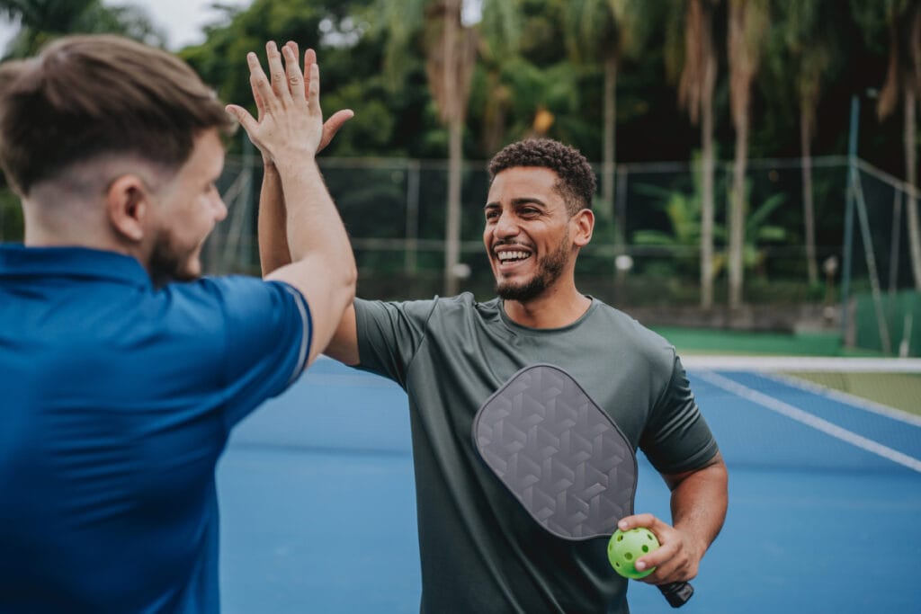 Two people high fiving after a tennis match