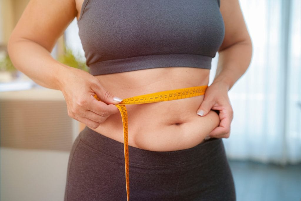 Woman measuring abdomen to take measurements before gastric band surgery