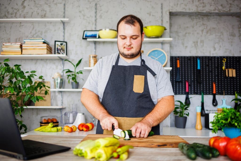 Overweight man cooking healthy meals to prepare for gastric band procedure